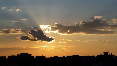 Silhouette city against sky during sunset