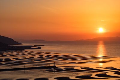 Scenic view of sea against orange sky