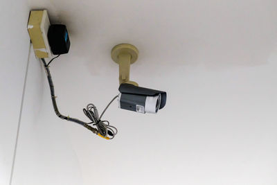 Low angle view of security camera on wall