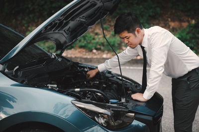 Side view of man holding car