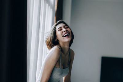 Young woman smiling while standing at home