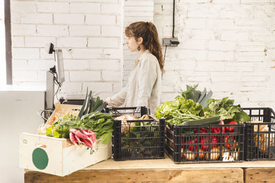 Grocer using weight scale in greengrocer shop