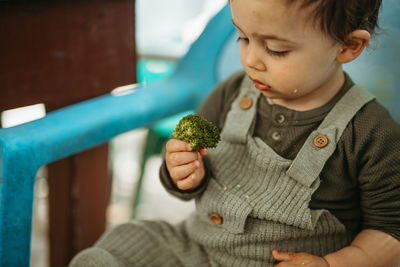 Cute boy holding broccoli