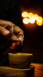 Close-up of hand holding wineglass on table