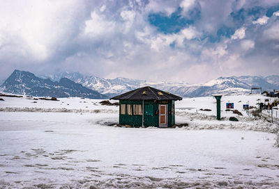 Built structure on snowcapped mountain against sky