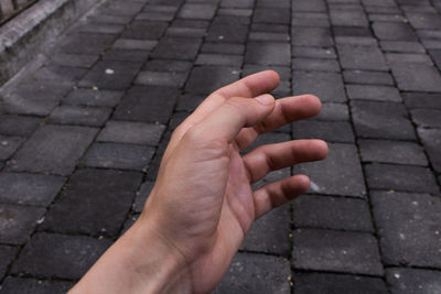 Close-up of hands on footpath