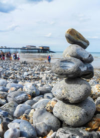 Stack of stones on beach against sky