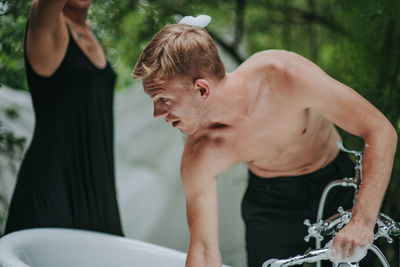 Midsection of shirtless man in bathroom