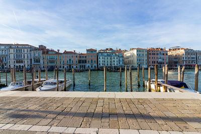 Boats moored at harbor against buildings in city