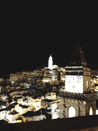 Illuminated buildings against sky at night