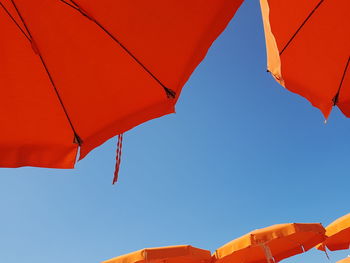 Low angle view of beach umbrella hanging against sky