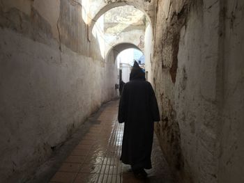 Rear view of woman walking in corridor