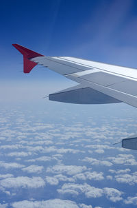 Window view of blue sky and fluffy clouds from passenger seat on airplane. concept of travel