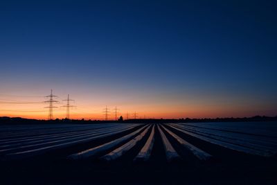 Surface level of electricity pylon against clear sky during sunset