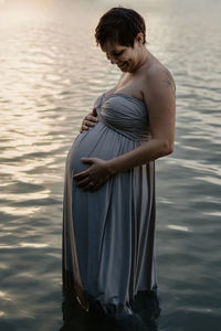  pregnant woman standing in lake