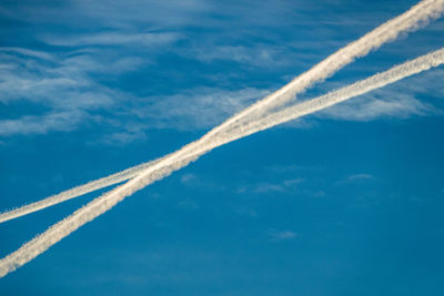 Low angle view of vapor trail against blue sky