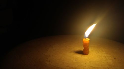 Close-up of illuminated light candle in darkroom