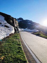 Road by mountains against clear sky