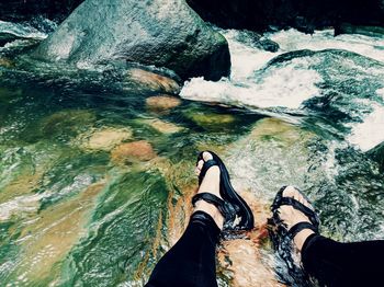 Low section of person on rock in river