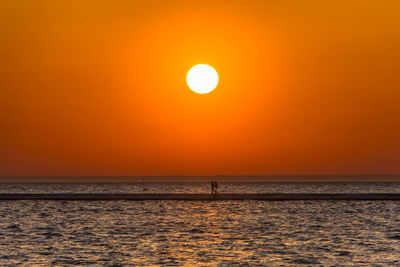 Scenic view of sea against orange sky