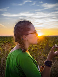 Portrait of man standing on field against sky during sunset