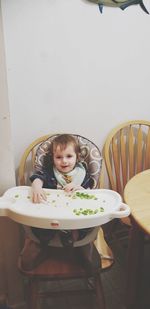 Portrait of cute boy sitting on table