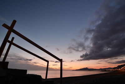 Scenic view of silhouette beach against sky during sunset