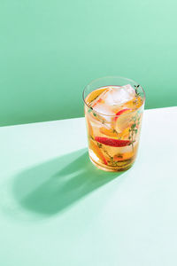 Refreshing peach iced tea cocktail in glass with straw. summer refreshing fruit drink.