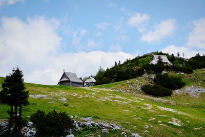 Built structure on landscape against cloudy sky