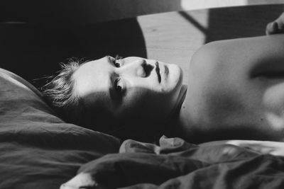 Portrait of shirtless man lying in bed