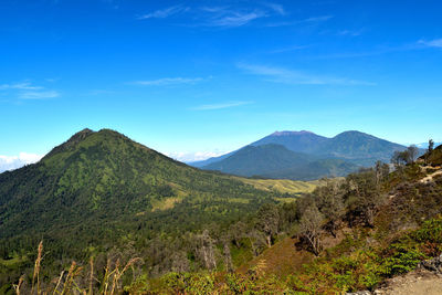 Scenic view of mountains against blue sky