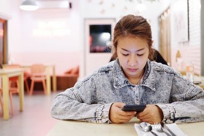 Mid adult man using mobile phone on table