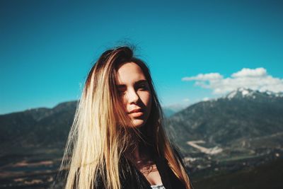 Beautiful young woman against blue sky