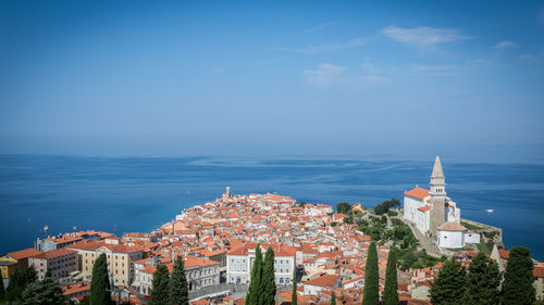 High angle view of townscape by sea against sky