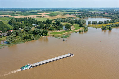 High angle view of river amidst trees against sky