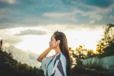 Side view of woman standing against sky