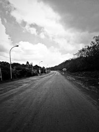 Empty road with trees in background