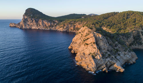 Rock formations by sea against sky