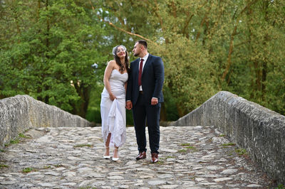 Full length of couple standing on footpath