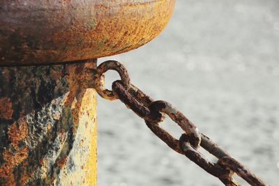 Close-up of rusty chain on bollard