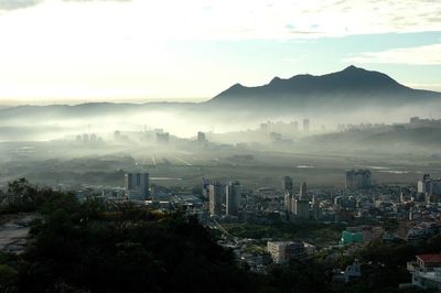 Cityscape against cloudy sky