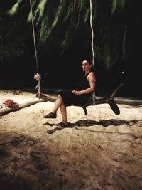 Young woman sitting on sand