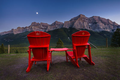 Red chairs and tables against clear sky