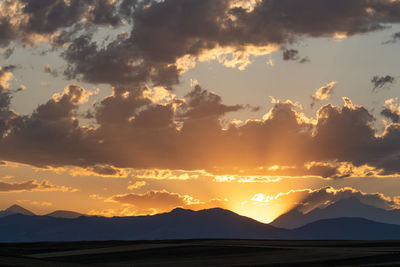 Scenic view of silhouette mountains against sky during sunset