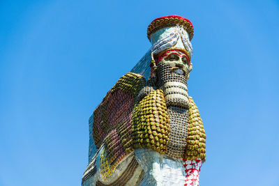 Low angle view of statue against blue sky