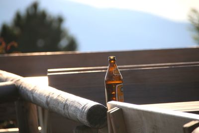 Close-up of hand holding glass bottle on table