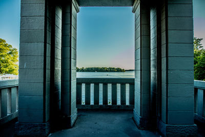 Bridge over river by buildings against sky