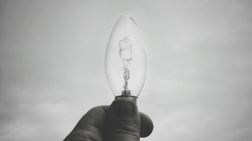 Low angle view of person hand against sky