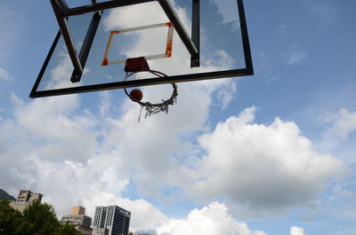 Low angle view of basketball hoop against clouds