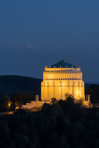 Illuminated building against sky at dusk